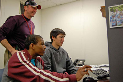 JLab Staffer Ed Daly looks on as Andrew Adderley (left) and Chris Aymonin (right) choose pictures to submit with the CAD drawing.