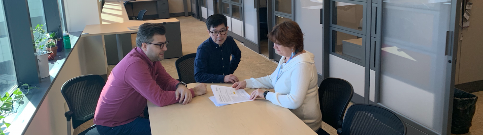 Image of people working together around a table
