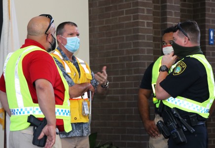Lt. Cupp (in red, left), speaks with Brian Hanlon and NNPD officers about the exercise