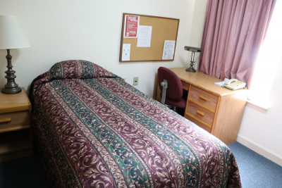 1980s design hotel room with wooden desk, old bedspread