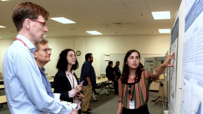 A student presents her poster to the judges in the poster competition at the 2019 JLUO meeting