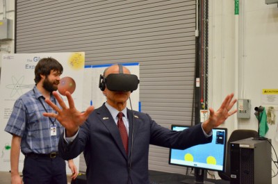 Menezes with virtual reality headset, arms outstretched