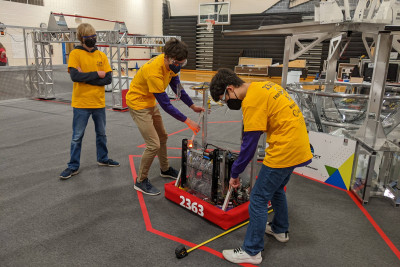Triple Helix robot with students adjusting